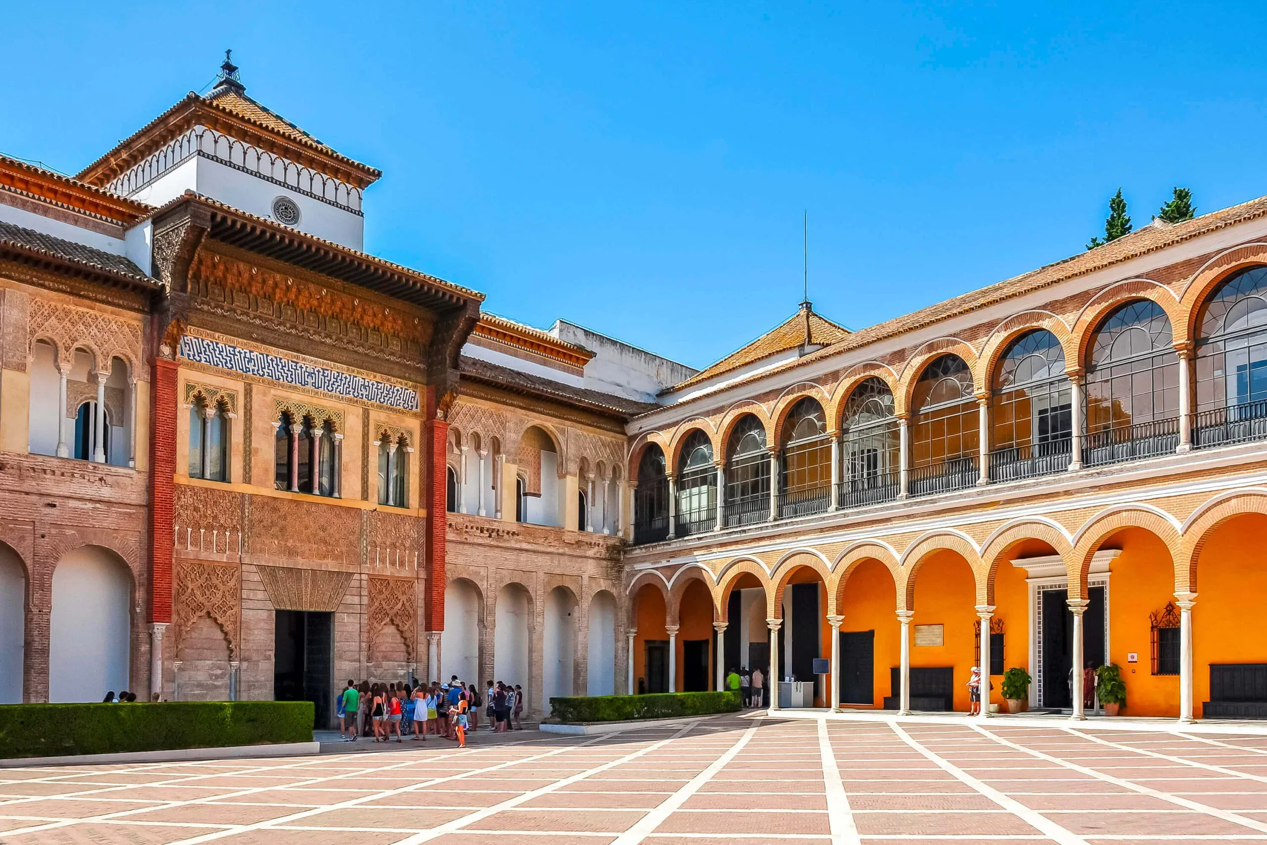 Sunlit palace facade and arched gallery at the Royal Alcázar of Seville