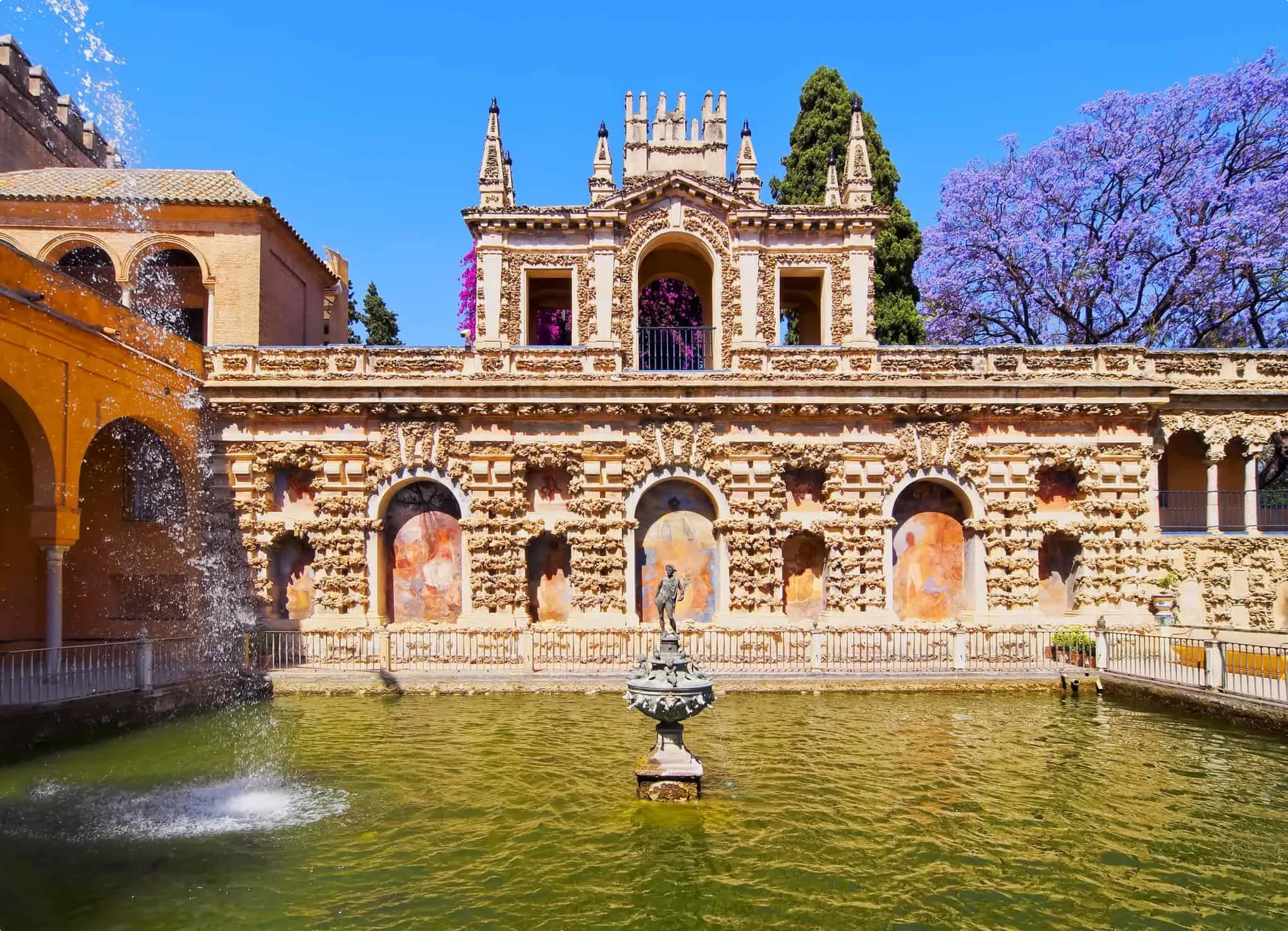 Garden fountain set amid greenery and tiled edging in Alcázar grounds