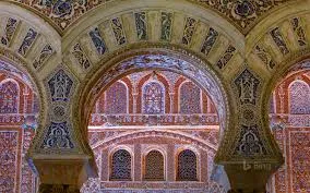 Decorative window frame meeting glazed tiles and carved stucco details